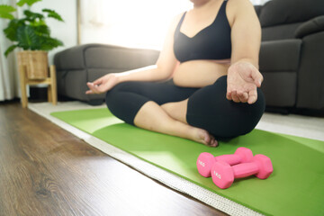 Fototapeta premium Overweight woman exercising for weight loss. exercise with dumbbells in stretching positions at home in the living room Cheerful&nbsp;Fat woman diet healthy lifestyle concept.