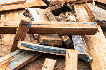 Construction waste after dismantling the formwork of a reinforced concrete foundation. Utilization of construction waste. Old boards, beams and formwork panels at a construction site.