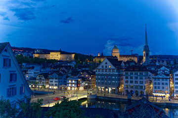 Fototapeta na wymiar Aerial view over the old town of Zürich with Limmat River and city lights on a spring evening with dramatic sky. Photo taken May 6th, 2023, Zurich, Switzerland.