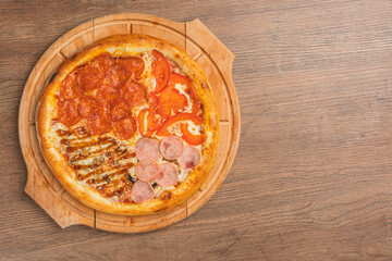 Fresh classic pizza with tomato sauce, mozzarella, spicy chorizo, bell pepper on a wooden background