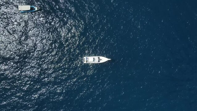 Top Down Aerial View of Yacht Boat Anchored in Deep Blue Water of Tropical Sea