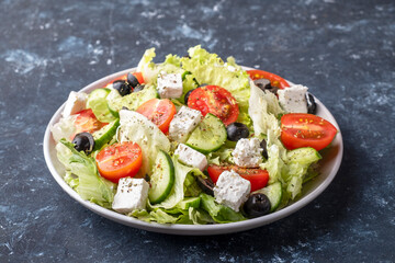 Salad with vegetables, feta cheese and olives. Healthy and diet food concept.