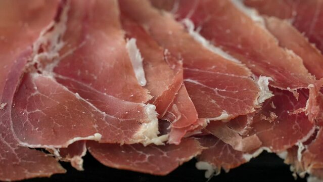 plate of sliced spanish iberico ham on wooden table background