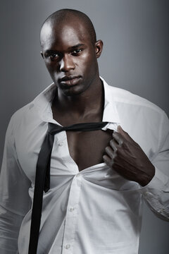 Portrait, sexy and black man with muscle, body and wellness against a dark studio background. Face, male person and model with confidence, attractive and handsome with sensual look and muscular guy