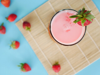 top view of Strawberry milkshake drink with strawberries on a glass