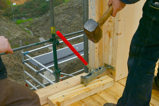 Mit dem Brettrichter kann der Zimmermann schwere vorgefertigte Vollholz-Bauelemente oder Balken passgenau an bereits aufgebaute Elemente gedrückt und mit Schrauben fixiert werden