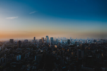 春の東京の夕暮れ　ビル街と夕日