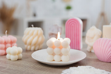 Fototapeta na wymiar Burning colorful handmade candles on the table