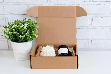 Fototapeta premium Aroma candles in a box and plant on table with copy space