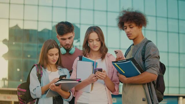 Group of Attractive Students Talking and Using a Smartphone Near of University. Young Leaders. Digital Education. Future Technologies. Graduates on the Verge of New Achievements