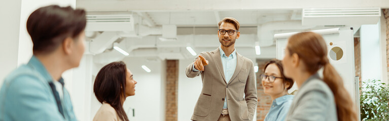 Obraz premium Leader standing in office and explaining new ideas to colleagues