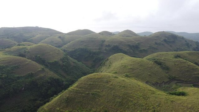 Aerial view, bizzare looking big rolling Teletubbies Hills in Nusa Penida Island, Bali - Indonesia.
Fertile tropical grassy Farmland Hills and a tourist attraction for its unique geologic cone shape