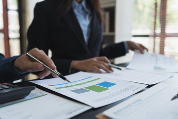 Group of modern business people pointing to data from graph papers Chart discussing in the conference room on Report, Sales, Target, Marketing, Concept.