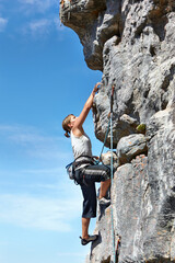 Rock climbing, explore and challenge with woman on mountain for adventure, travel and fitness. Strong, freedom and blue sky with climber training in nature for courage, safety and workout mockup