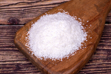 Coconut powder. Grounded coconut flakes on a wood flipchart. dessicated coconut