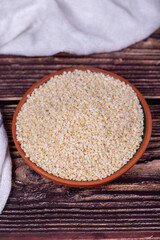 Sesame seeds on wooden background. Organic White Sesame seeds (Sesamum indicum) in Earthen bowl