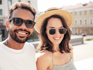 Smiling beautiful woman and her handsome boyfriend. Woman in casual summer clothes. Happy cheerful family. Female having fun. Sexy couple posing in the street at sunny day. In hat and sunglasses