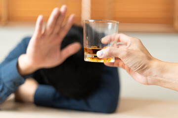 Depressed young Asian man addicted feeling bad drinking whiskey alone at home, stressed frustrated lonely drinking alcohol suffers from problematic liquor, alcoholism, life and family problems