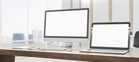 Modern designer office desk with empty white mock up computer screens, supplies and blurry interior with windows and city view background. 3D Rendering.