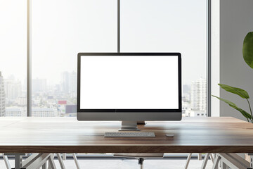 Front view of a modern office workplace with wooden desk with white screen computer, on city view window background in light interior, mockup. Webdesign and project presentation concept. 3D Rendering