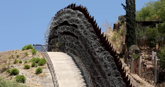 Daytime view of the fortified USA Mexico border wall as it runs through downtown Nogales, Arizona, USA.