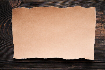 Ripped piece of craft paper mockup with copy space on wooden background
