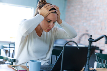 Portrait of frustrated young woman working at home office