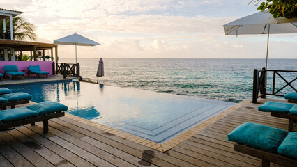 sunset by a swimming pool during a vacation in Curacao during holiday at a tropical island luxury vacation