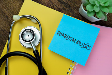 Concept of Rhabdomyolysis write on sticky notes with stethoscope isolated on Wooden Table.