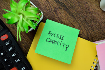 Concept of Excess Capacity write on sticky notes isolated on Wooden Table.