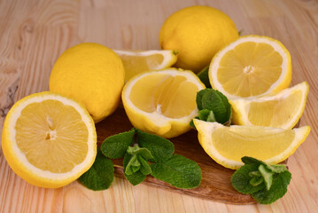 Fresh lemons and mint leaves on a wooden background.