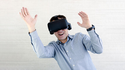 Happy man in VR glasses is screaming. Male in 3d headset is dancing on white background. Concept of human emotions,facial expression, modern gadgets and technologies.