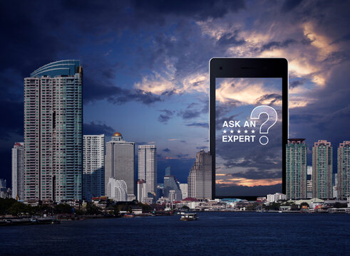 Ask an expert with star and question mark sign icon on modern smart mobile phone screen over office city tower, river and sunset sky, Business communication online concept