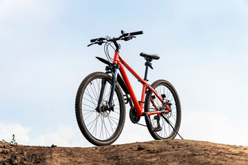 Fototapeta na wymiar Off-road driving. Vintage bike in orange color against background with blue sky