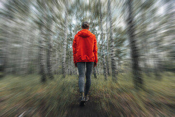 Back of a woman in orange jacket walking on a dirt road in the forest with pink jacket. Lifestyle concept. blurry motion effect - Powered by Adobe