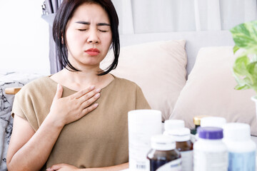 Asian woman with an allergic reaction to supplements symptoms of difficulty breathing and nausea