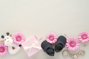Baby girl, pregnancy announcement, flat lay composition with space for text or product, baby accessories, pink gerbera flowers, gift box.
