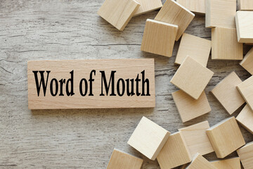 Word of Mouth. text on a wooden block. next to wooden cubes