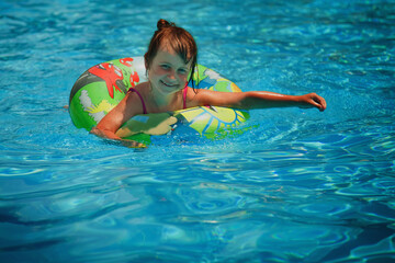 Pretty little girl in the outdoor pool. Horizontal image. Copy space.