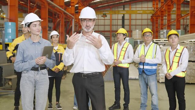 Foreman and group of workers applaud after factory manager is successfully trained.in the morning before starting to work in production plant.Safety first concept,Planning and production procedures.
