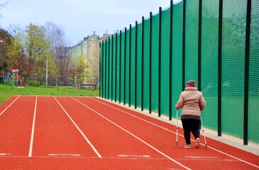 Woman are going - Nordic walking style runs on the tracks for sprint running
