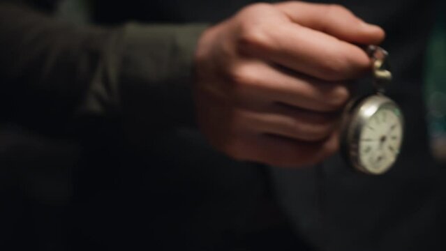 Man holds pocket watch in hand