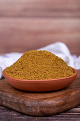 Ground cumin or Jeera Powder. Powder cumin spice in bowl on wooden background. Dry spice concept. Close up