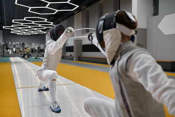 Duel of fencers during fencing match, training lesson at martial art class