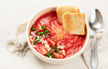 Tomato soup on white table, top view