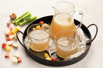 Glass jar with yellow fresh bone broth on white background. Healthy low-calories food is rich in vitamins, collagen and anti-inflammatory amino acids.