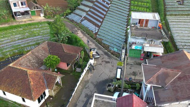 Aerial view of Entrance on the gate on the Butuh Village, Nepal Van Java tourist village with the icon is Golden statue of Mountain climber. One of the hiking trails of Mount Sumbing - 4K Drone video
