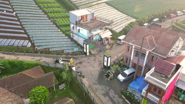 Drone View : Golden statue of Mountain climber Entrance on the gate from the village of Butuh, Nepal Van Java. Famous tourist village on the slope of Mount Sumbing, Central Java, Indonesia - 4K video