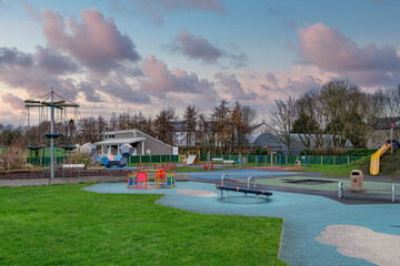 A modern Children's Play ground or park fitted with new safe play equiptment of promary colours