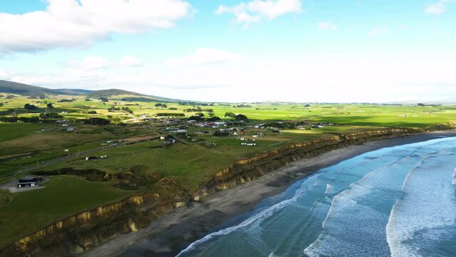 Aerial over the small town of Orepuki on the Te Waewae coast, South Island, New Zealand. Drone truck left shot